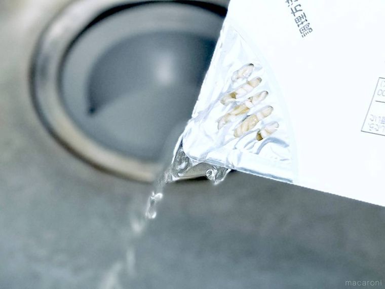 カップ焼きそばのお湯をシンクに捨てている様子