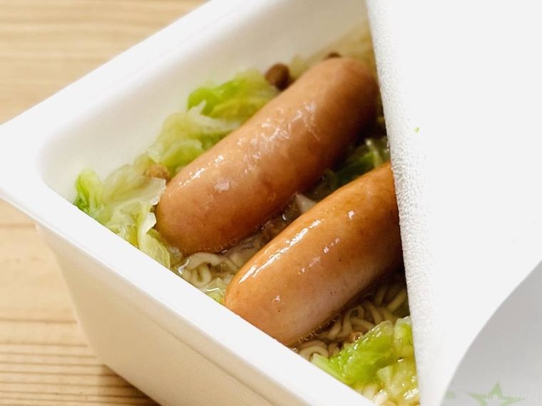 お湯が入ったカップ焼きそばにウインナーを入れた様子