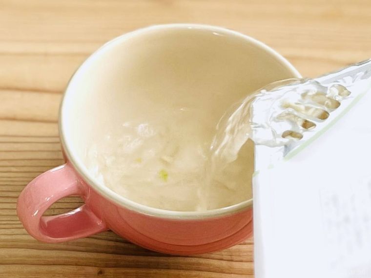 カップ焼きそばのお湯をスープカップに入れている様子