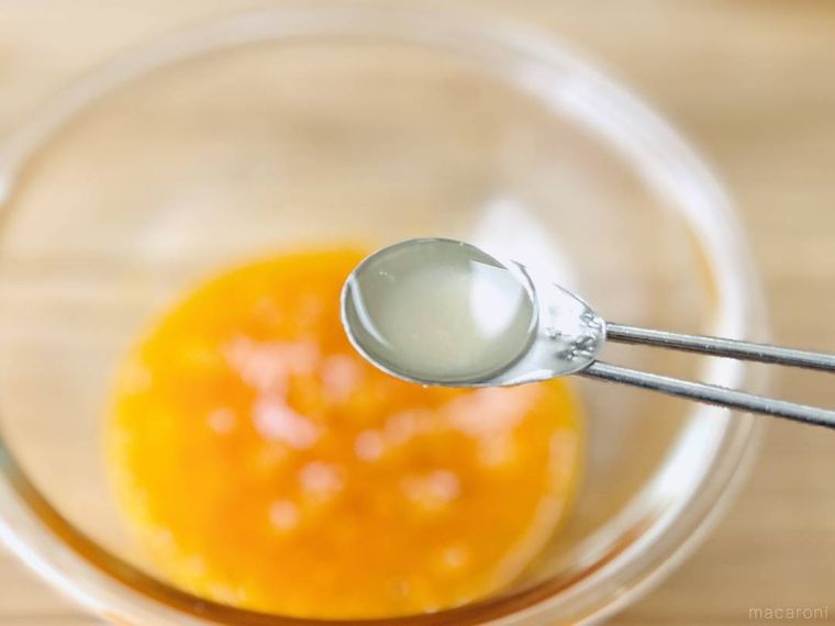 卵液にツナ缶の油を入れようとしている様子