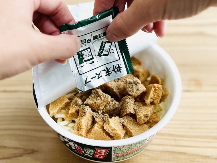 どん兵衛 きつねうどんに粉末スープを入れている様子