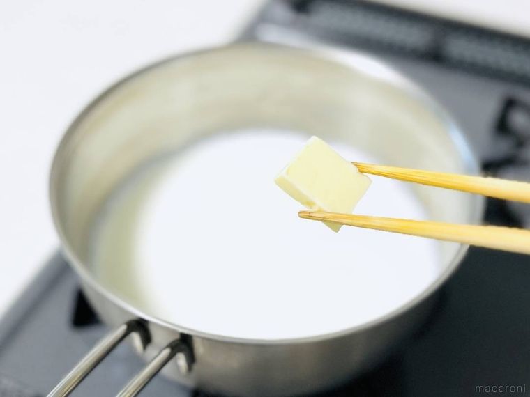 温めた牛乳にバターを入れようとしている様子