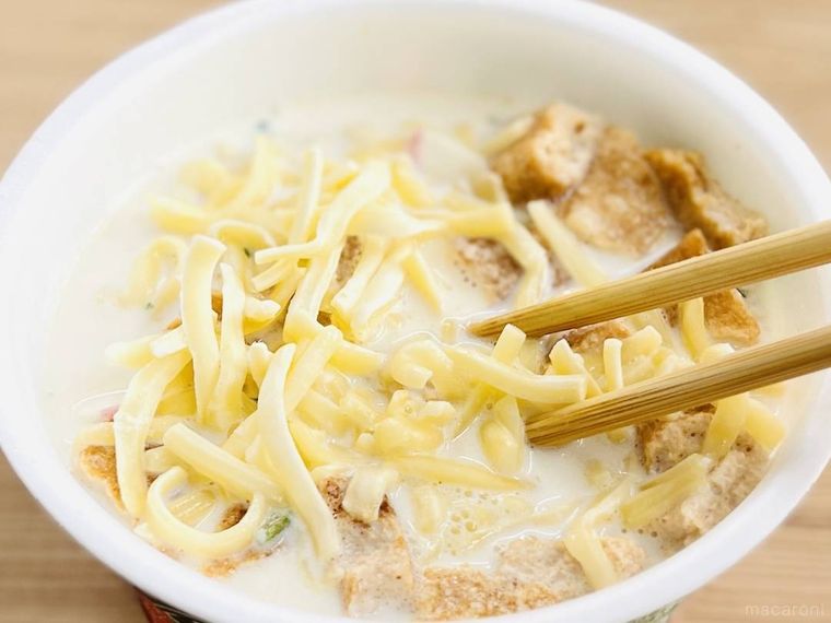 牛乳が入ったどん兵衛 きつねうどんにピザ用チーズを加えた様子