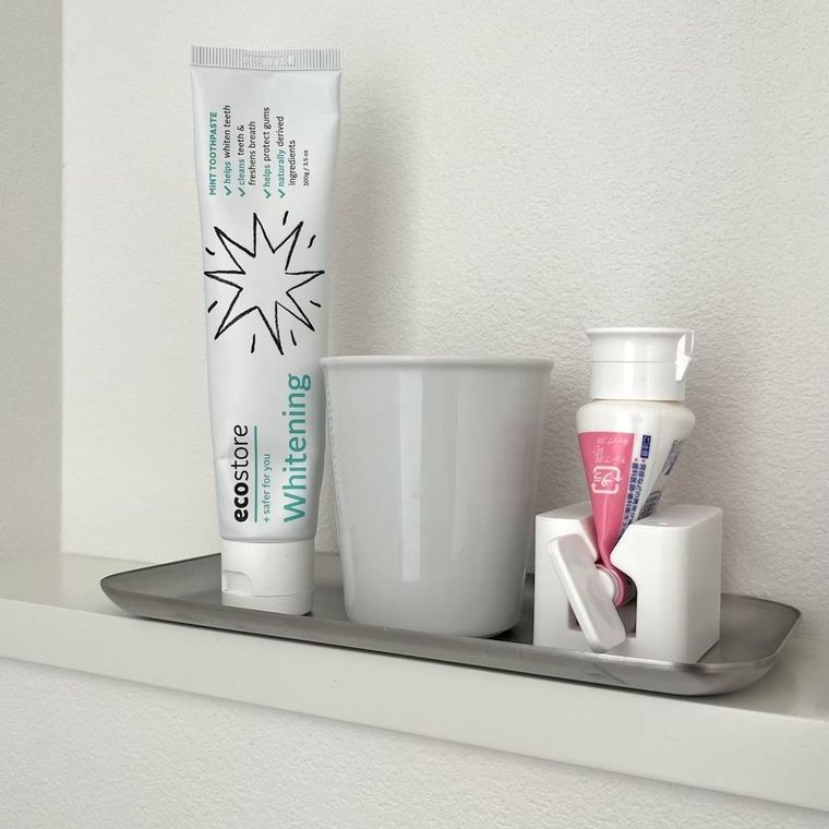 歯磨き粉チューブとコップが並べて置いてある