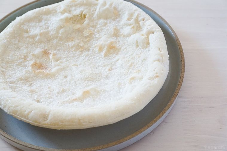 灰色の皿にのせたピザ生地