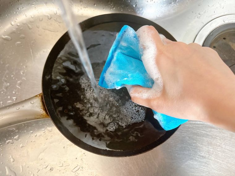 洗剤を使ってフライパンを洗う様子