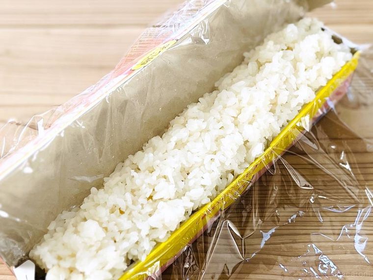ラップを敷いたラップの空箱に酢飯を詰めた様子