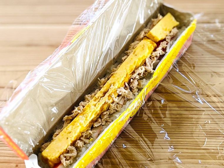 ラップを敷いたラップの空箱に酢飯と具を詰めた様子
