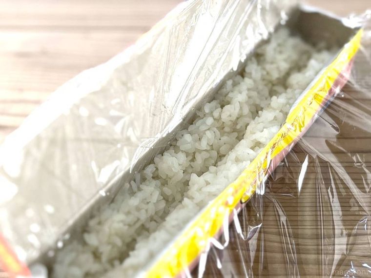 ラップを敷いたラップの空箱に酢飯を詰めた様子