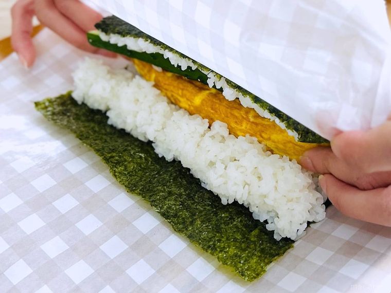 クッキングシートで恵方巻を作っている様子