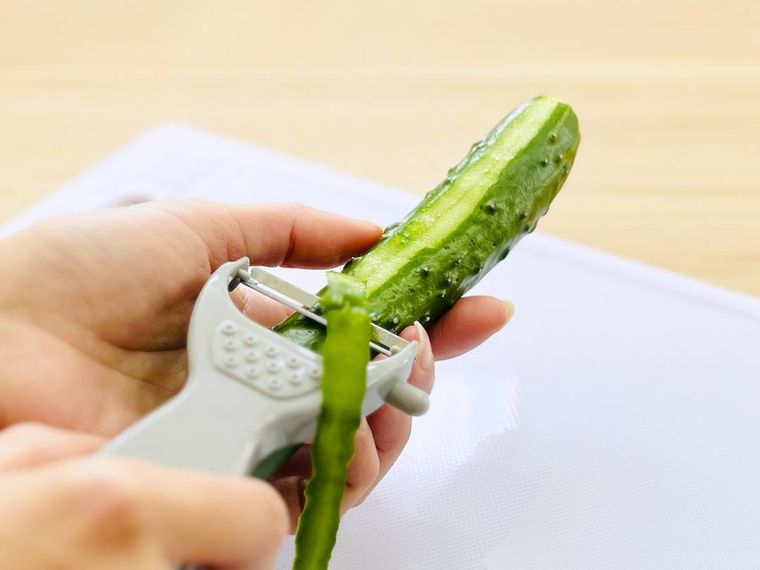 ピーラーできゅうりの皮をむいている様子