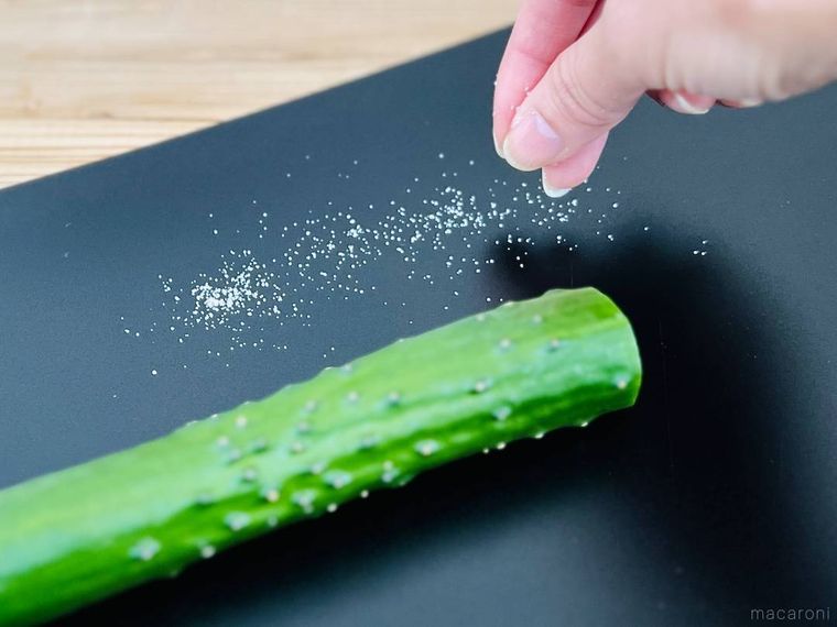 きゅうりがのったまな板に塩をまいている様子