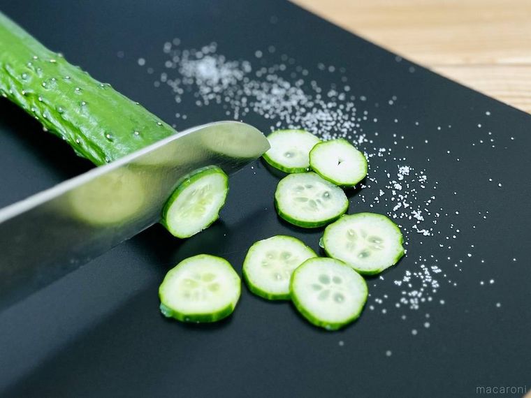 塩をまいたまな板の上できゅうりを輪切りにしている様子