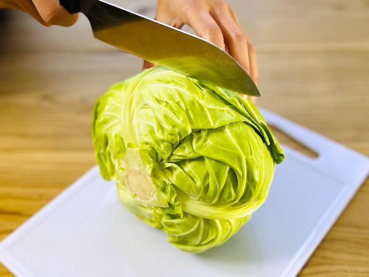 キャベツを立てた状態で半分に切っている様子