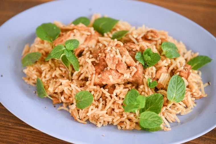 ミントをのせた青い皿に盛られた完成したビリヤニ