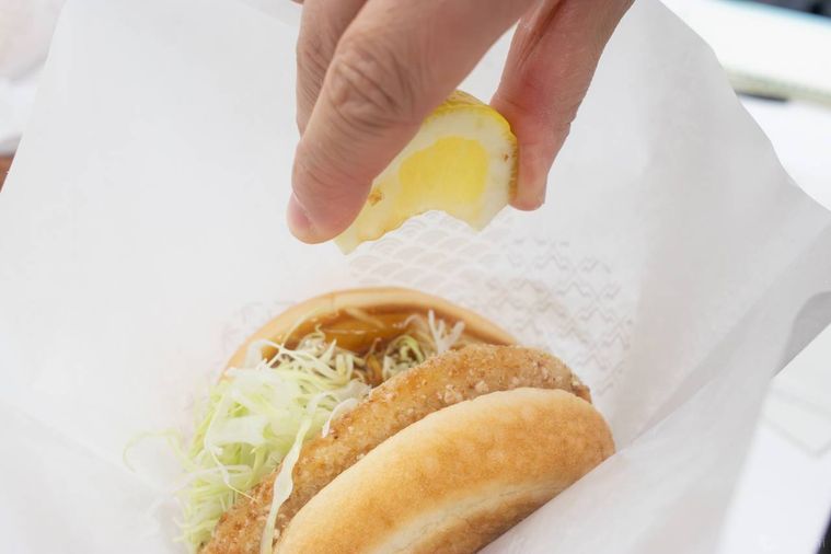 モスバーガー和風旨だれのとり竜田バーガーくし切りレモン添えのレモンを絞っている様子