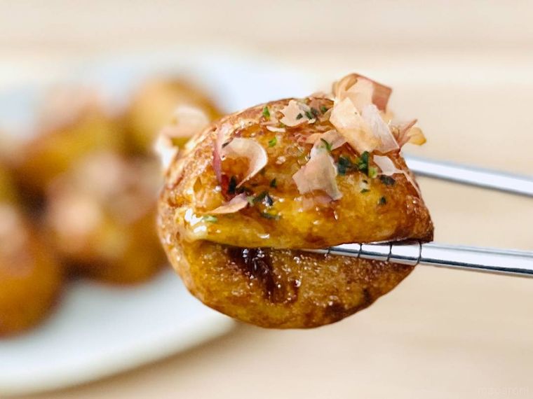 たこ焼きを箸で持ち上げている様子