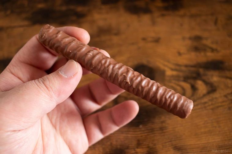 ヨックモックショコラ シガールのリッチミルクを手で持っている