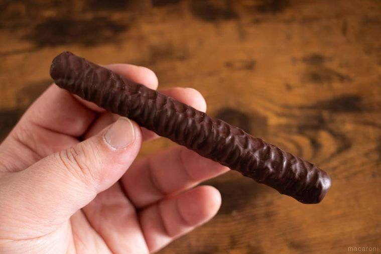 ヨックモックショコラ シガールのリッチビターを手で持っている