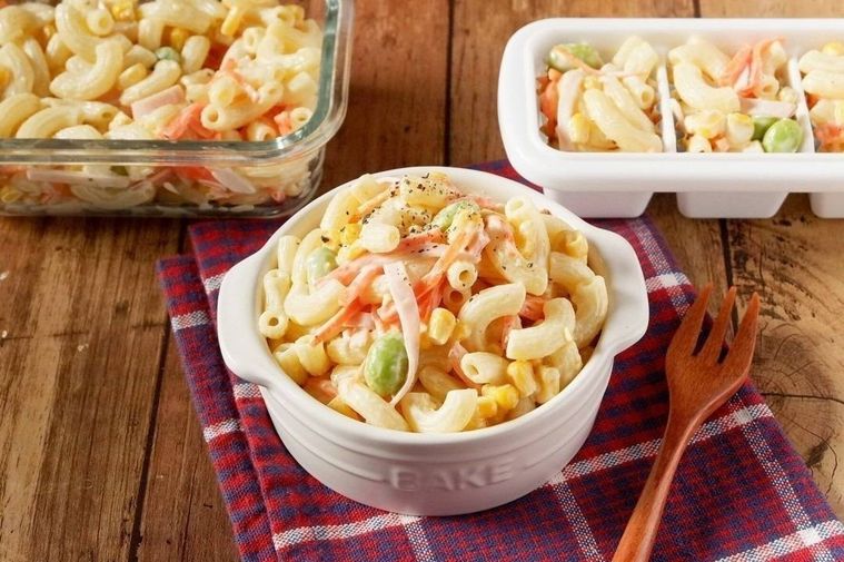 白い皿に盛ったマカロニサラダと保存容器に入れたマカロニサラダ