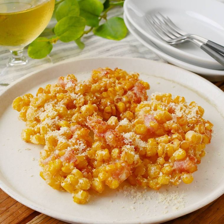 白い皿に盛られたとうもろこしと生ハムのかき揚げ