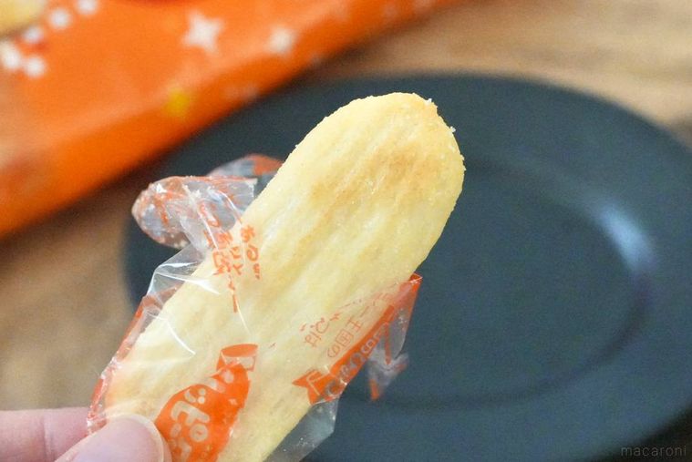 黒い小皿と手に持ったハッピーターンせんべい