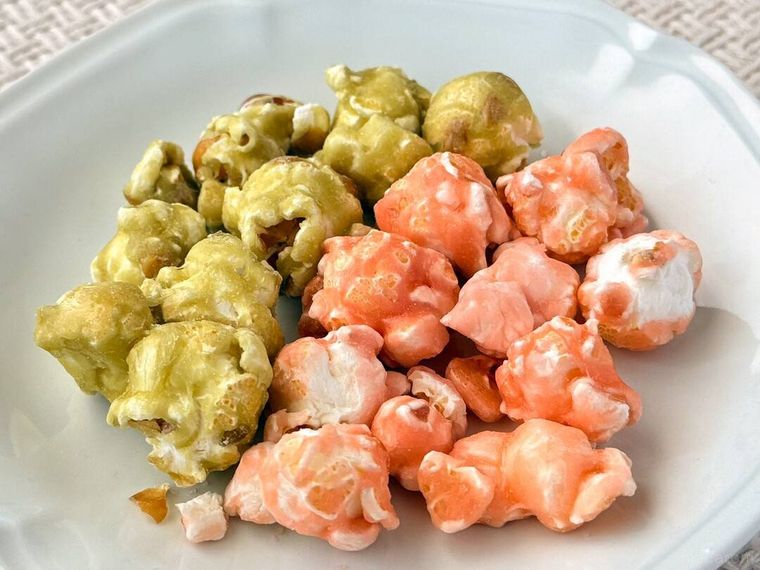 白皿にのった桜と抹茶のキャンディングポップコーンがテーブルの上に置かれている様子