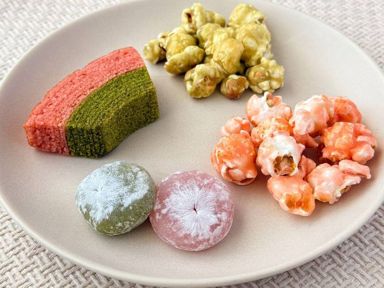 桜と抹茶のひとくち大福や桜と抹茶のキャンディングポップコーンなどが皿に盛り付けられている様子