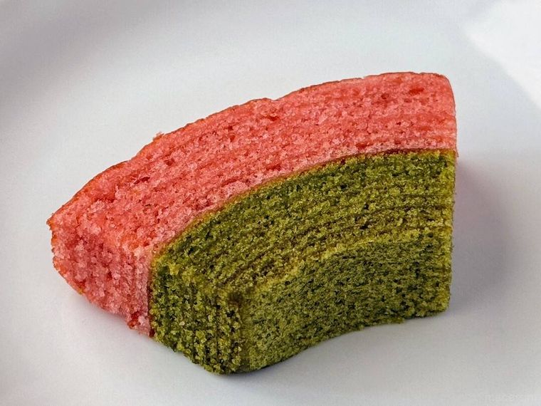 白皿にのった 桜と抹茶のカットバウムがテーブルの上に置かれている様子