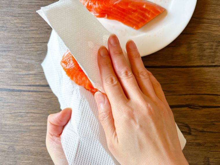 生鮭をキッチンペーパーで拭く様子