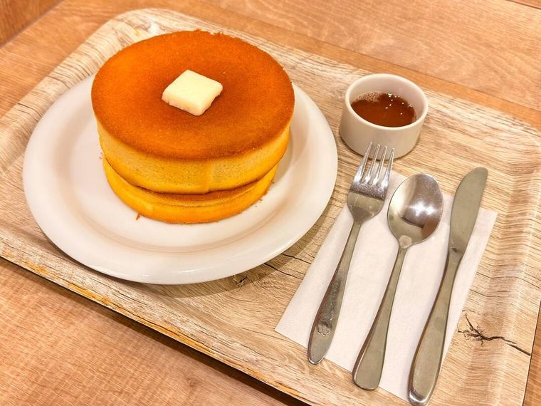 ナイフやフォークなどが添えられたモスバーガーのダブル ふんわりスフレパンケーキメープルシロップ