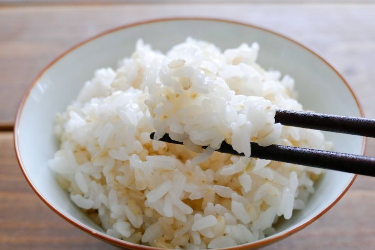 玄米と白米の混ぜご飯を箸で持ち上げる様子