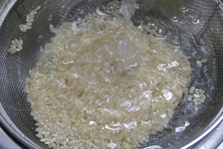 玄米を流水ですすぐ様子