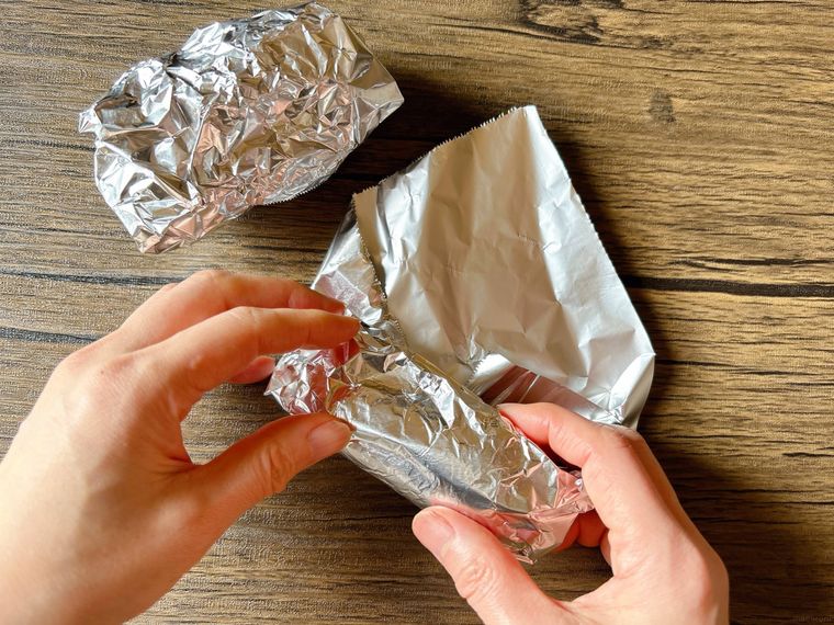 さつまいもをアルミホイルで包む様子