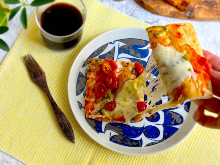 手で持ったコストコのマルゲリータピザのチーズが溶けて伸びているところ