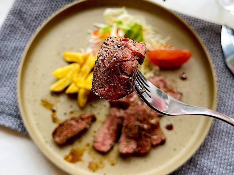 カットしたコストコのハラミステーキを1枚フォークにとったところ