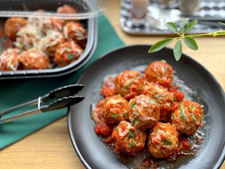 パッケージに入ったコストコのポークミートボールと、それを盛り付けた黒いプレート