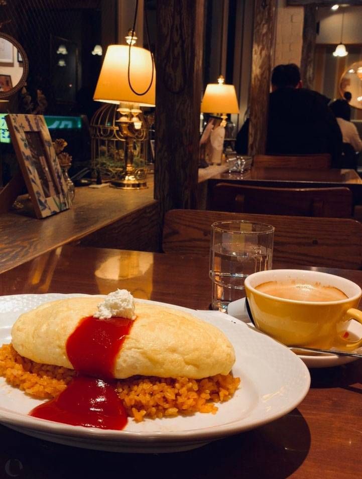 白い皿に盛られたスフレ卵のオムライスとコーヒー