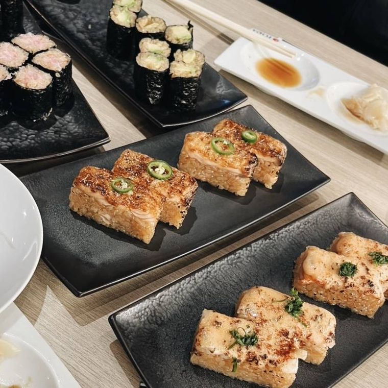 黒い器に盛られた炙り寿司と巻き物