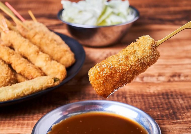 串カツにソースをつけている様子