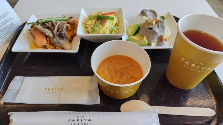 黒いトレーに並んだ魚料理やスープなど