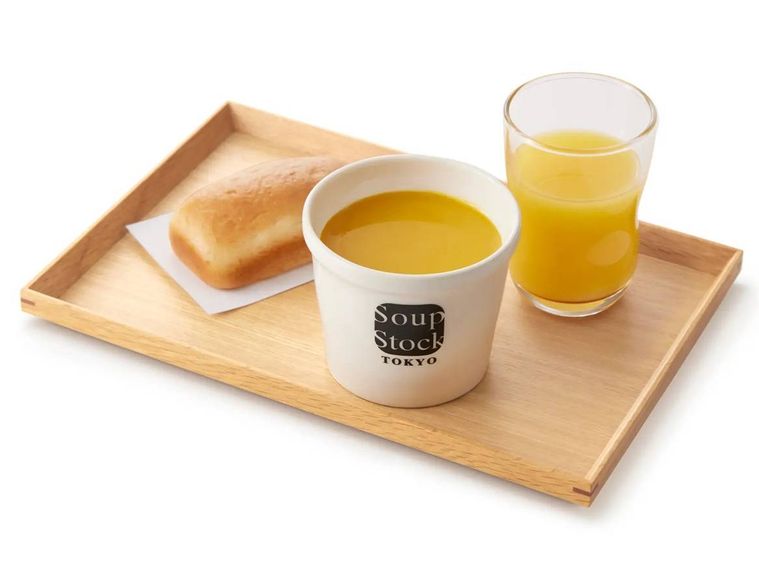 木製トレーにのったスープとパンとジュースのセット