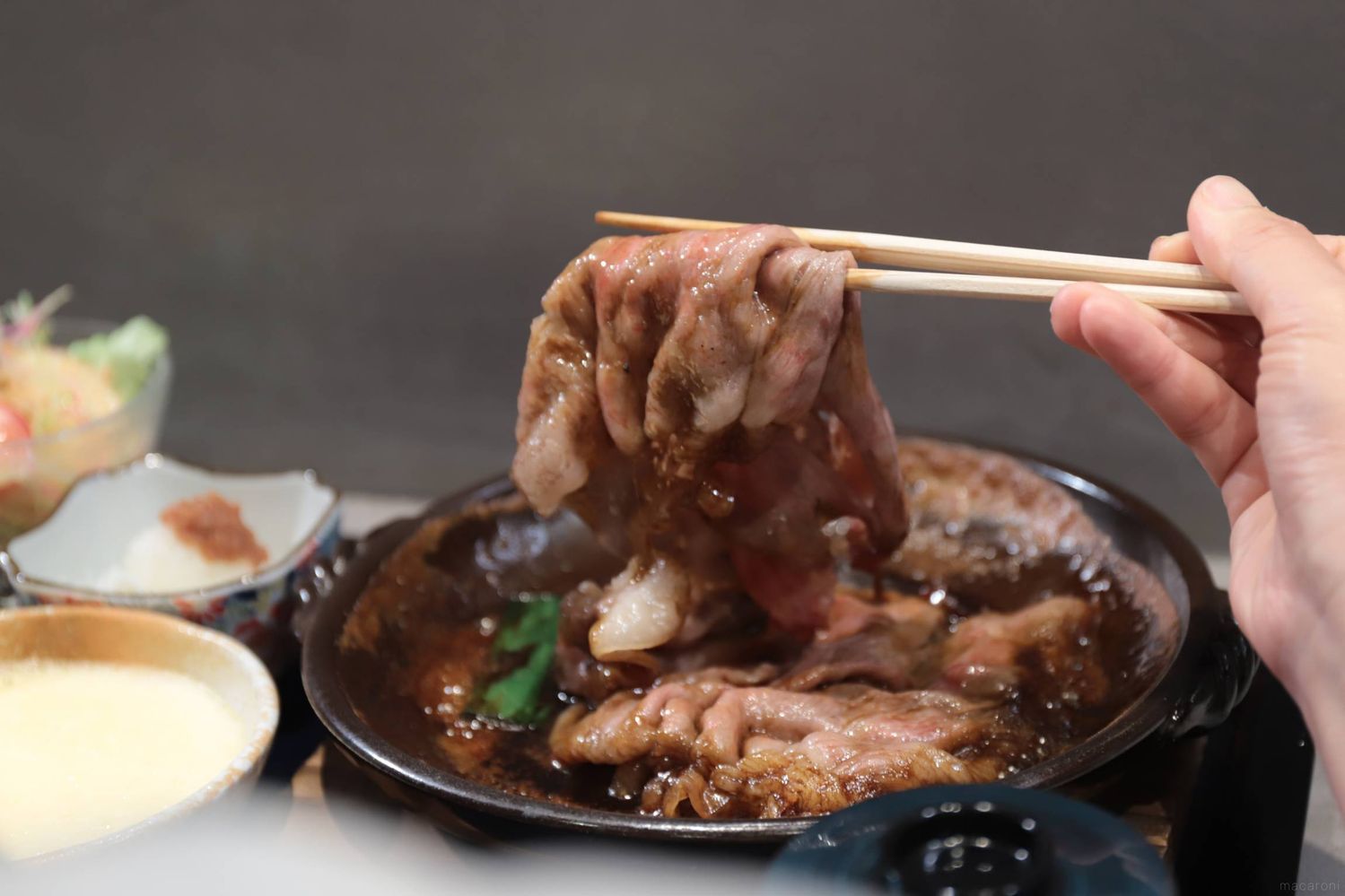 和牛のすき焼きを箸で持ち上げている
