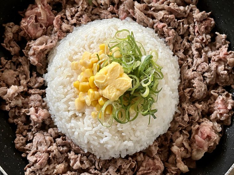 フライパンの中央のごはんのまわりに牛肉、中央に具材をおいたところ