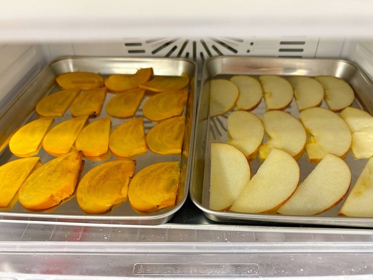 薄くスライスした柿、りんごを冷凍する様子