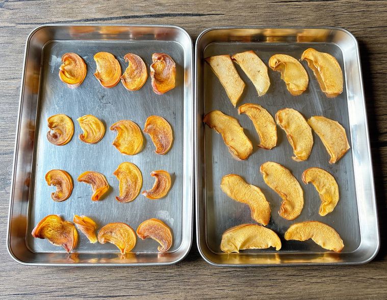 金属トレーに並んだりんごと柿のフリーズドライ風