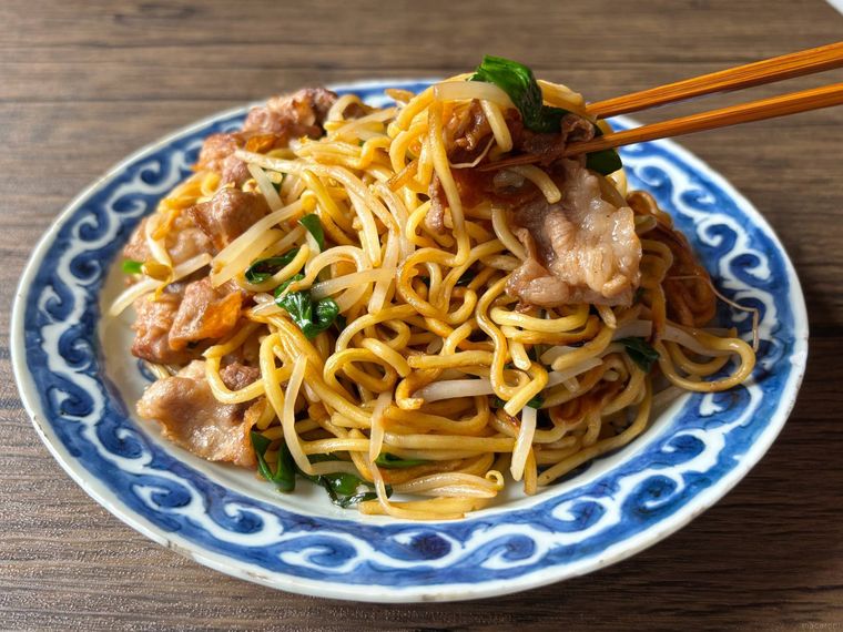 青色の和皿に盛られた日田焼きそばを箸あげする様子