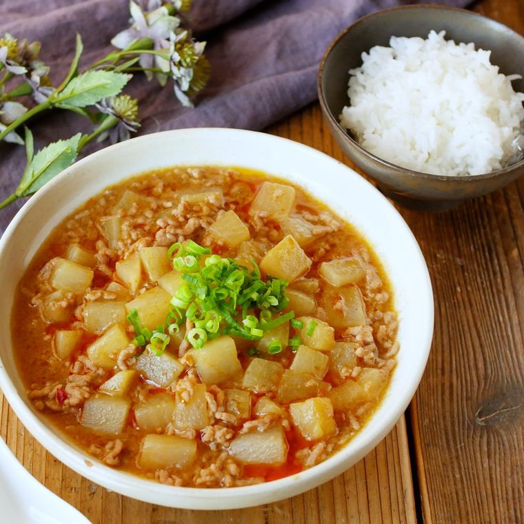 白い丼鉢に盛りつけられた麻婆大根とごはん入りのお椀