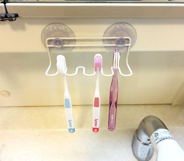 ワイヤー歯ブラシホルダーに3本の歯ブラシがぶら下がっている
