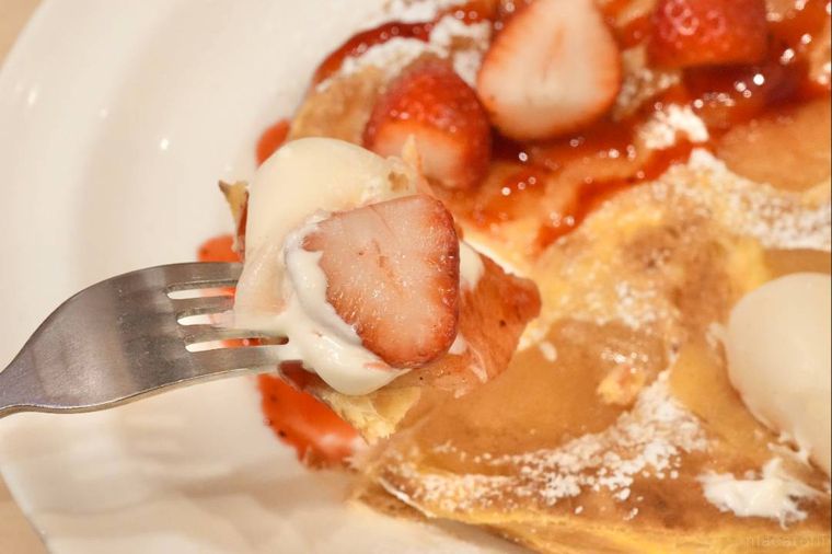 いちごと雪見だいふくがトッピングされたりんごパイを銀のフォークとナイフで食べる様子